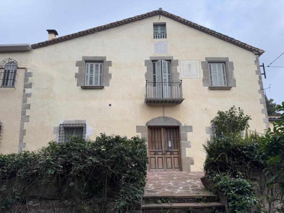 Façana principal de can Cinnamond amb el rellotge a mà dreta de la balconera. 