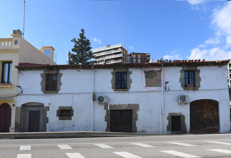 Imatge de conjunt amb el rellotge situat a la planta pis, al costat d'un baixant d'aigua. 