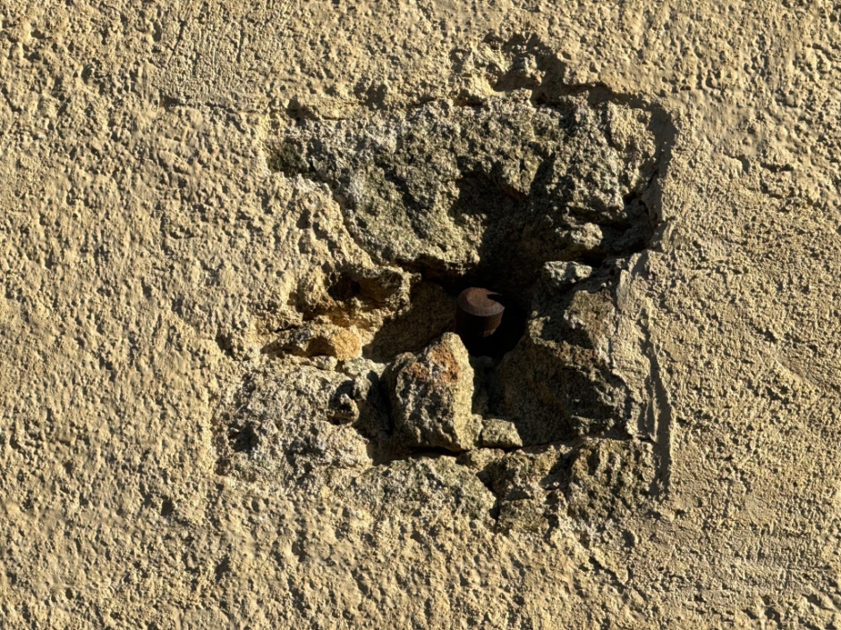 Detall de l'impacte provocat pel projectil, dessota el rellotge de sol de la façana principal de l'església. 
