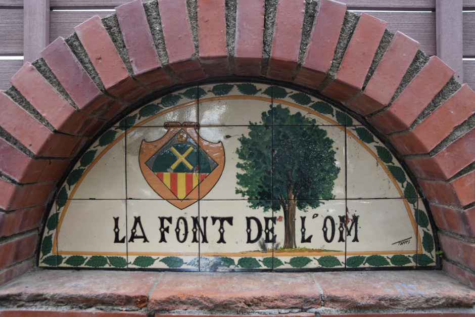 Capcer amb un plafó ceràmic policromat amb el nom de la font. 