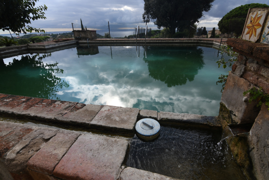 Vista general de la bassa amb safareig per a  rentar la roba i font a primer terme i uns rajols ceràmics del segle XVIII al damunt. 