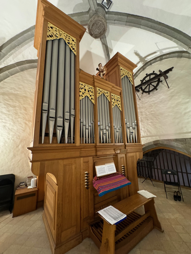 Vista de costat de l'orgue amb la façana amb la consola tapada i la banqueta. 